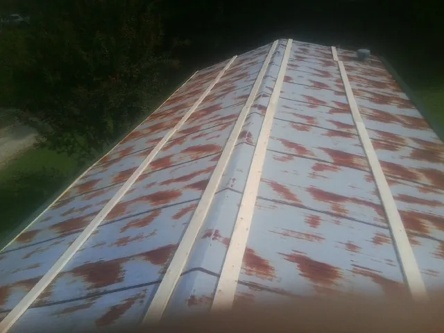 Rusted metal roof panels with new wood purlins before replacement — Storm Damage Roof Repair in Moultrie by Roofing Brothers