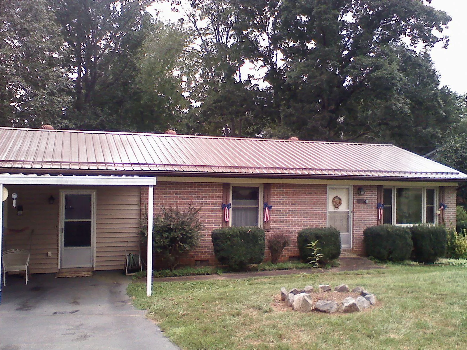Bronze metal roof and carport on a brick ranch home — Roof Repair work by our crew in Moultrie